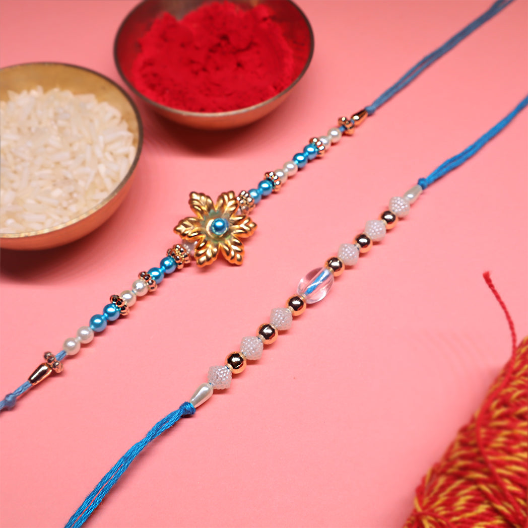 Ocean Bloom Rakhi Duo – Floral Gold & Crystal Blue Elegance